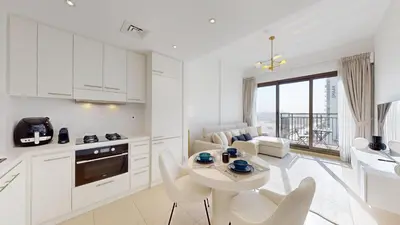 a kitchen and living room with a table and chairs at UNA Tower - Peaceful One Bedroom in Townsquare in Dubai
