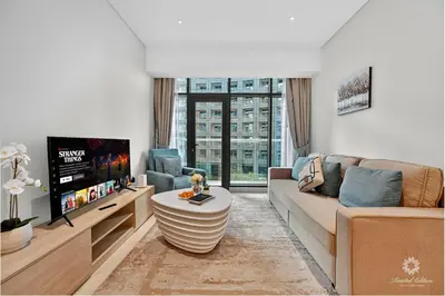 a living room with a couch and a tv at Seven Palm Residences - Private Beach Access, Infinity Pool with Sea View in Dubai