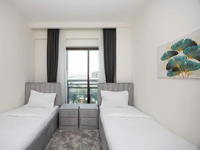 two beds in a room with a window at Beach View family friendly unit in Dubai in Dubai