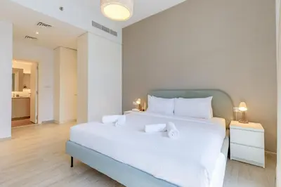 a bedroom with a large white bed with white pillows at Stylish 2BR Apartment in Belgravia III A, JVC - Allsopp & Allsopp in Dubai
