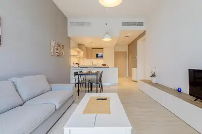 a living room with a couch and a table at Stylish 2BR Apartment in Belgravia III A, JVC - Allsopp & Allsopp in Dubai