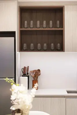 a kitchen with a shelf with utensils on it at Stylish 1BR City View at Vida Creek Beach in Dubai