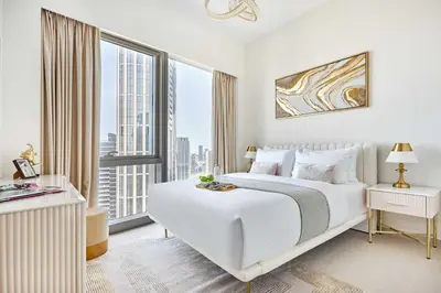 a bedroom with a white bed and a large window at Frank Porter - Grande Signature Residence in Dubai
