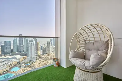 a rattan chair in a room with a large window at Frank Porter - Grande Signature Residence in Dubai
