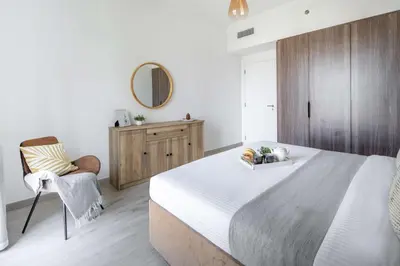 a bedroom with a large bed and a chair at Frank Porter - Lamtara 3, MJL in Dubai
