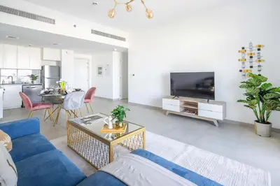 a living room with a blue couch and a tv at Frank Porter - Lamtara 3, MJL in Dubai