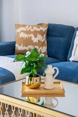 a blue couch and a table with a plant on it at Frank Porter - Lamtara 3, MJL in Dubai