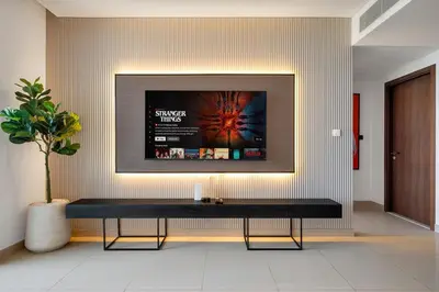 a black bench in a room with a tv on the wall at Trendy 1BR Dubai Dream with full BurjViews Above Dubai Mall in Dubai