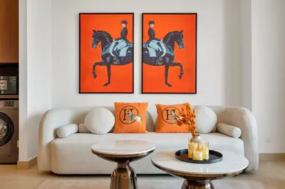 a living room with a couch and two paintings of horses at Trendy 1BR Dubai Dream with full BurjViews Above Dubai Mall in Dubai