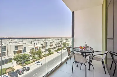 a balcony with a table and chairs and a view of a city at Frank Porter - Pulse Residence Park B3 in Dubai