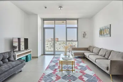 a living room with a couch and a table at Frank Porter - Pulse Residence Park B3 in Dubai