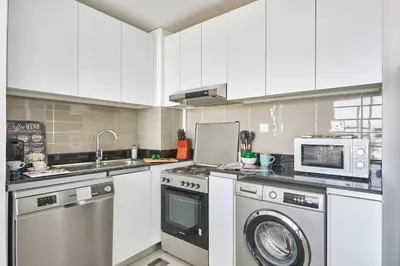 a kitchen with a washing machine and a microwave at Frank Porter - Pulse Residence Park B3 in Dubai