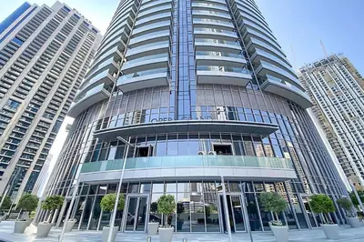a tall glass building with trees in front of it at 2BR with Iconic Burj and Dubai Fountain Views in Dubai
