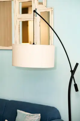 a lamp in a living room with a blue couch at Modern Elegance in a Cosy Retreat with Balcony - Azizi Riviera in Dubai