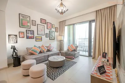 a living room with a couch and a tv at Bnbeyond's Artistic Luxe Retreat with Burj Views in Dubai