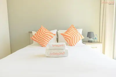 a white bed with four pillows on top of it at Bnbeyond's Artistic Luxe Retreat with Burj Views in Dubai
