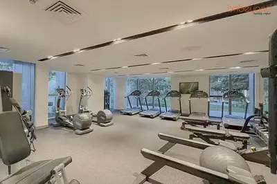 a gym with several treadmills and machines in it at Bnbeyond's Sky-High Luxe with Above and Beyond Views in Dubai