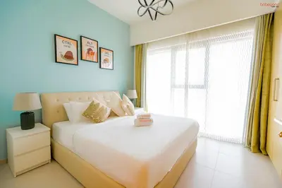 a bedroom with a large white bed and a window at Bnbeyond's Sky-High Luxe with Above and Beyond Views in Dubai