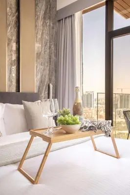 a coffee table with a bowl of grapes and wine glasses at Frank Porter - Westwood Grande in Dubai