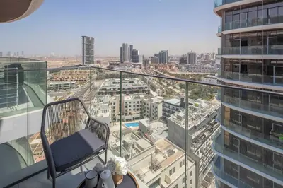 a chair on a balcony with a view of a city at Frank Porter - Westwood Grande in Dubai