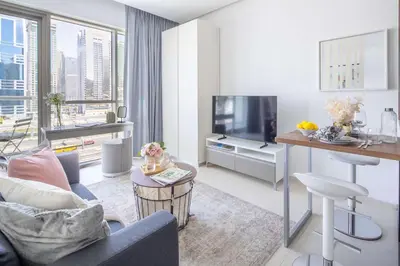 a living room with a couch and a tv at Frank Porter - West Avenue in Dubai
