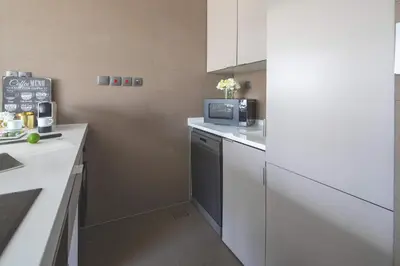 a kitchen with white cabinets and a microwave at Frank Porter - West Avenue in Dubai
