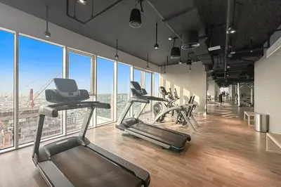 a gym with cardio equipment in a large room with windows at Dubai Frame Views Steps from Metro & Sheikh Zayed Road in Dubai