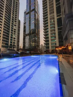 a large swimming pool in a city with tall buildings at Charming 1BR with Sea & City Views in Dubai
