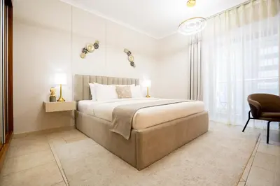 a bedroom with a large bed and a chair at Charming 1BR with Sea & City Views in Dubai