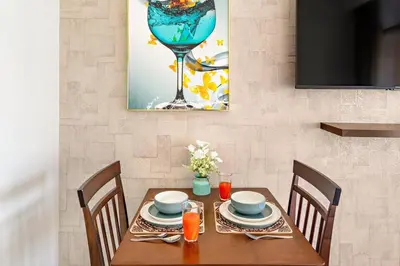 a dining room table with a wine glass and a table at FIRST CLASS Studio Modern Vibes in Dubai in Dubai