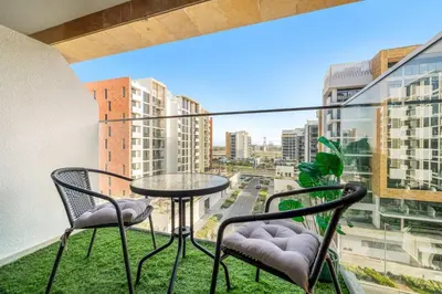 a balcony with a table and chairs and a view of a city at FIRST CLASS Studio Modern Vibes in Dubai in Dubai
