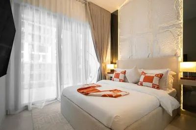 a bedroom with a white bed and a large window at Burj et Canal View Sunny Pool in Dubai