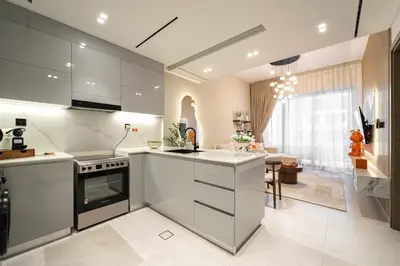 a kitchen with white appliances and a living room at Burj et Canal View Sunny Pool in Dubai