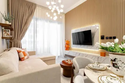 a living room with a couch and a tv at Burj et Canal View Sunny Pool in Dubai