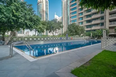 a swimming pool in a city with tall buildings at Bellavista - 1 Bedroom Apartment - 29 Boulevard in Dubai