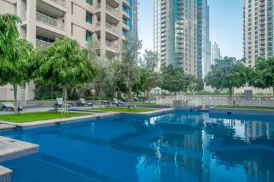 a swimming pool in a city with tall buildings at Bellavista - 1 Bedroom Apartment - 29 Boulevard in Dubai