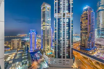 a city skyline at night with tall buildings at Modern 1BR JBR View No Car Needed! in Dubai
