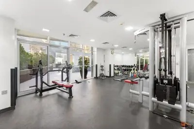 a gym with treadmills and machines in a room at Modern 1BR JBR View No Car Needed! in Dubai