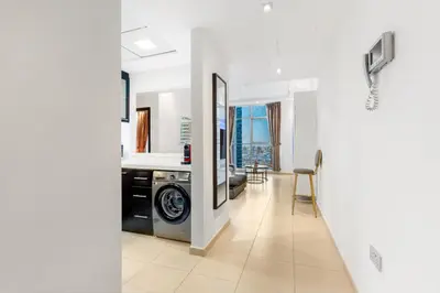 a laundry room with a washer and dryer in a house at Modern 1BR JBR View No Car Needed! in Dubai