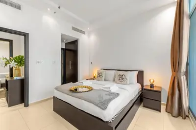 a bedroom with a large bed and a bathroom at Modern 1BR JBR View No Car Needed! in Dubai