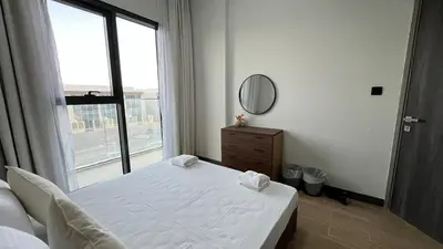 a bedroom with a bed and a mirror and a window at Daraqa - Modern 1BR Apartment in Peaceful Dubai Land in Dubai