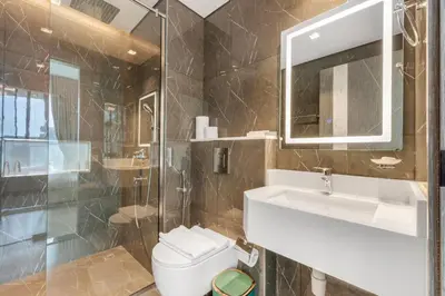 a bathroom with a toilet and a sink and a mirror at Chic One-Bed Haven w Pool & Gym Heart of Dubai in Dubai