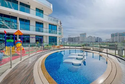a pool on the top of a building with a playground at Chic One-Bed Haven w Pool & Gym Heart of Dubai in Dubai