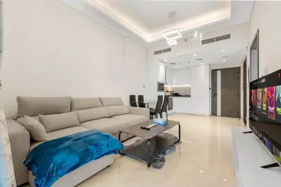 a living room with a couch and a tv at Chic One-Bed Haven w Pool & Gym Heart of Dubai in Dubai