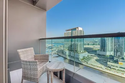 a balcony with two chairs and a view of a city at Live the Dubai Dream Premium Flat in Business Bay in Dubai