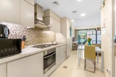 a kitchen with white cabinets and a stove top oven at Live the Dubai Dream Premium Flat in Business Bay in Dubai