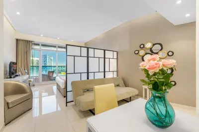 a living room with a vase of flowers on a table at Live the Dubai Dream Premium Flat in Business Bay in Dubai