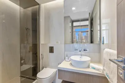 a bathroom with a sink and a toilet and a shower at Modern 1Bedroom w Burj Khalifa view in Peninsula in Dubai