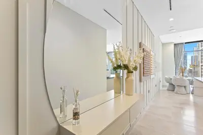 a hallway with white walls and a mirror at Modern 1Bedroom w Burj Khalifa view in Peninsula in Dubai