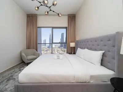 a bedroom with a large white bed and a window at Modern Downtown 2 Bed plus Maids with Full Burj View in Dubai